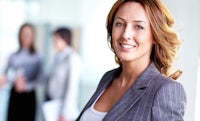 a business woman is smiling in front of a group of people